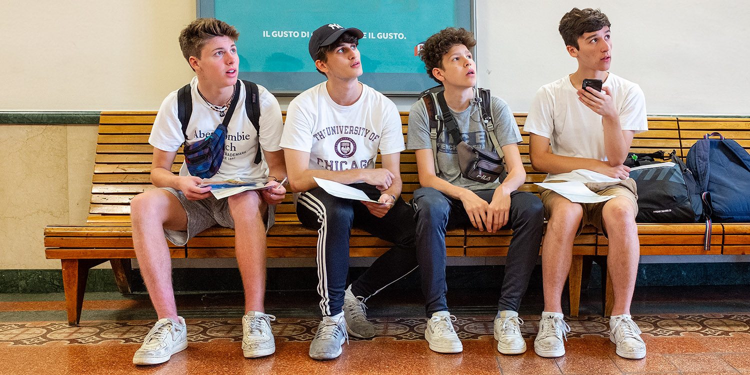 Young tourists studying the departure board at the train station