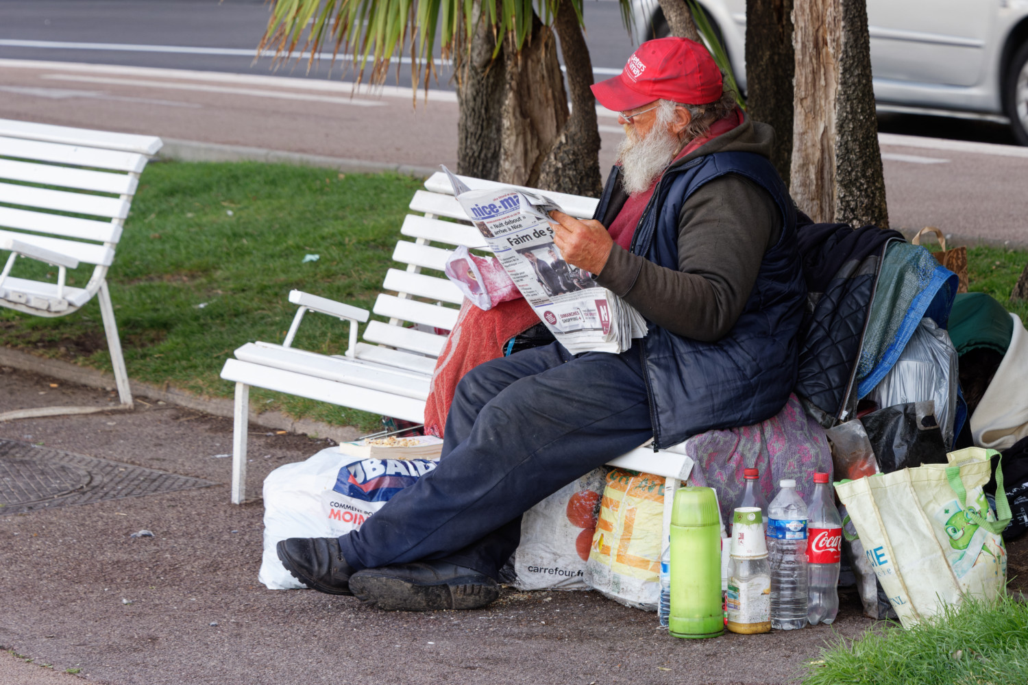 Homeless man reading the local newspaper