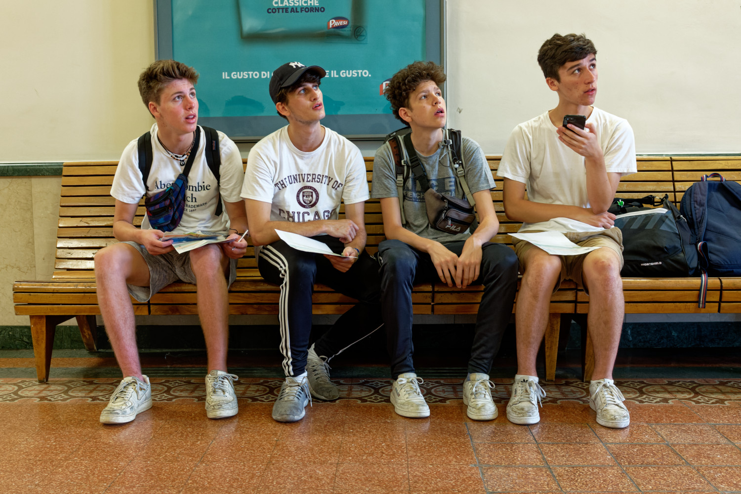 Young tourists studying the departure board at the train station