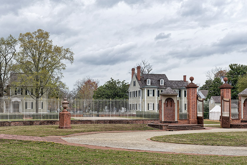 Between gate and palace where the carriages used to drive up