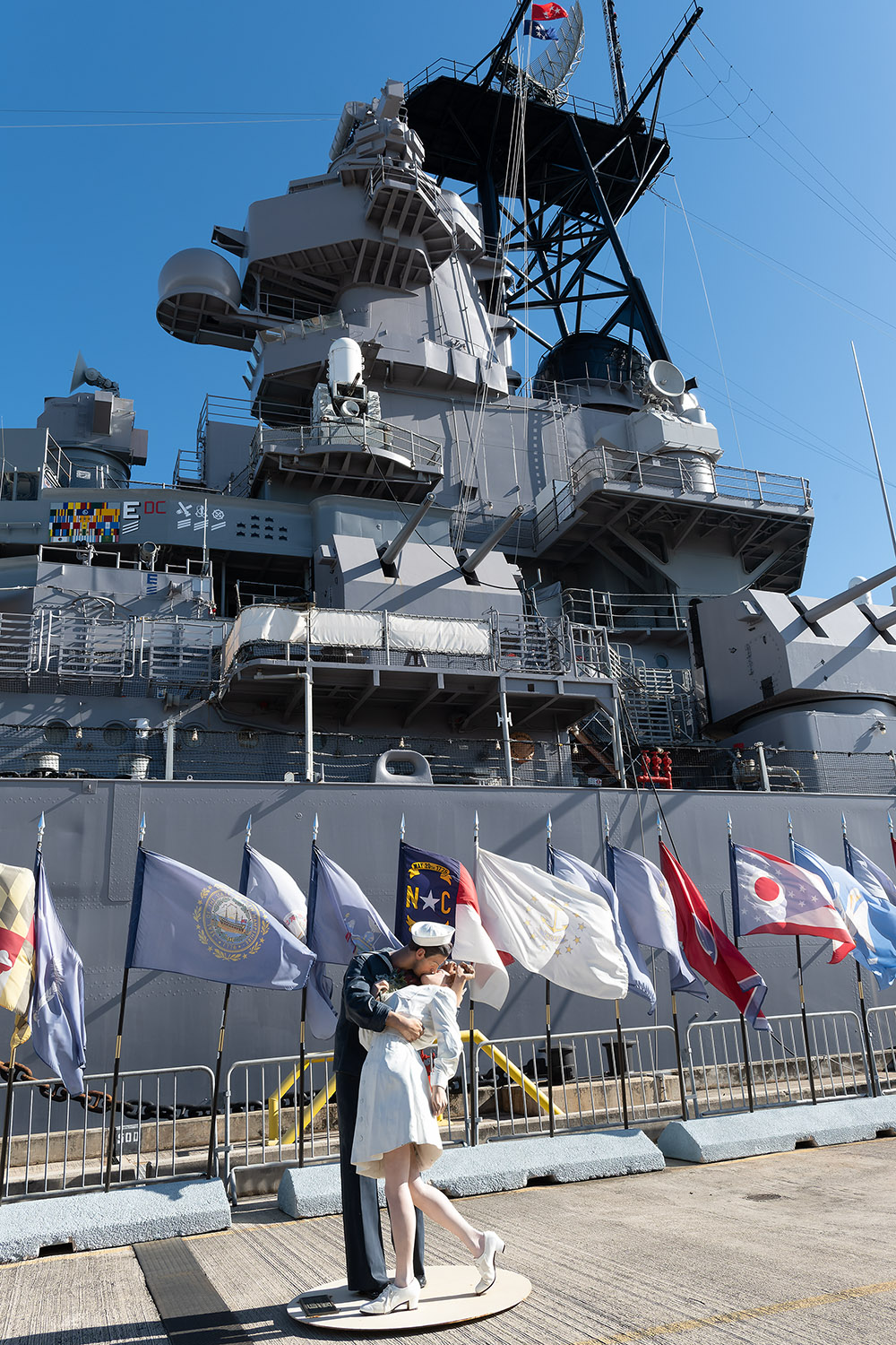 The U.S.S. Missouri behind a statue of a famous Alfred Eisenstaedt photograph