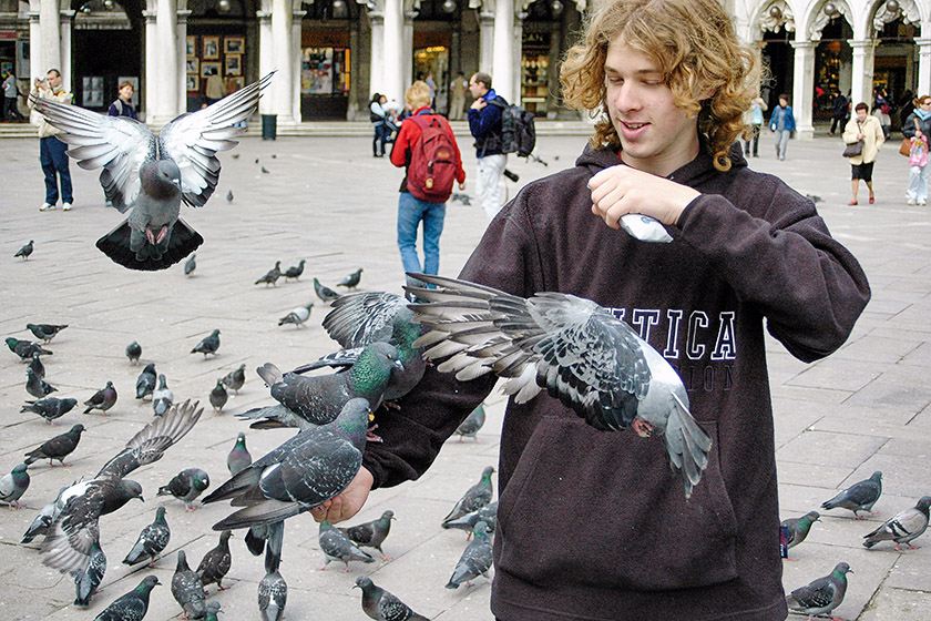 Tourists enjoy feeding the pigeons on the 'Piazza San Marco'